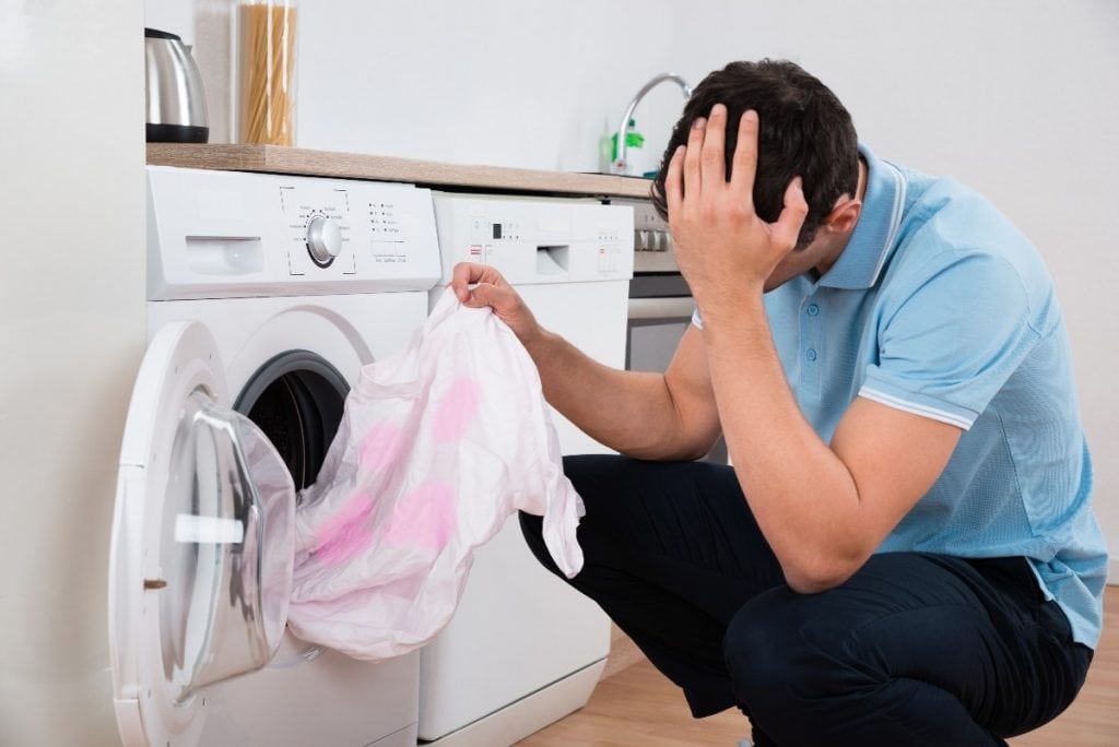 A man concerned about how to remove colour bleeding stains from clothes