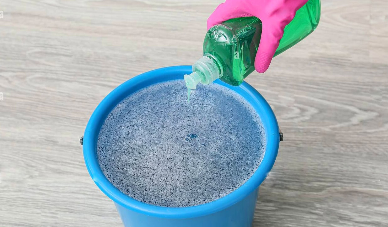 Adding detergent to water for hand washing clothes